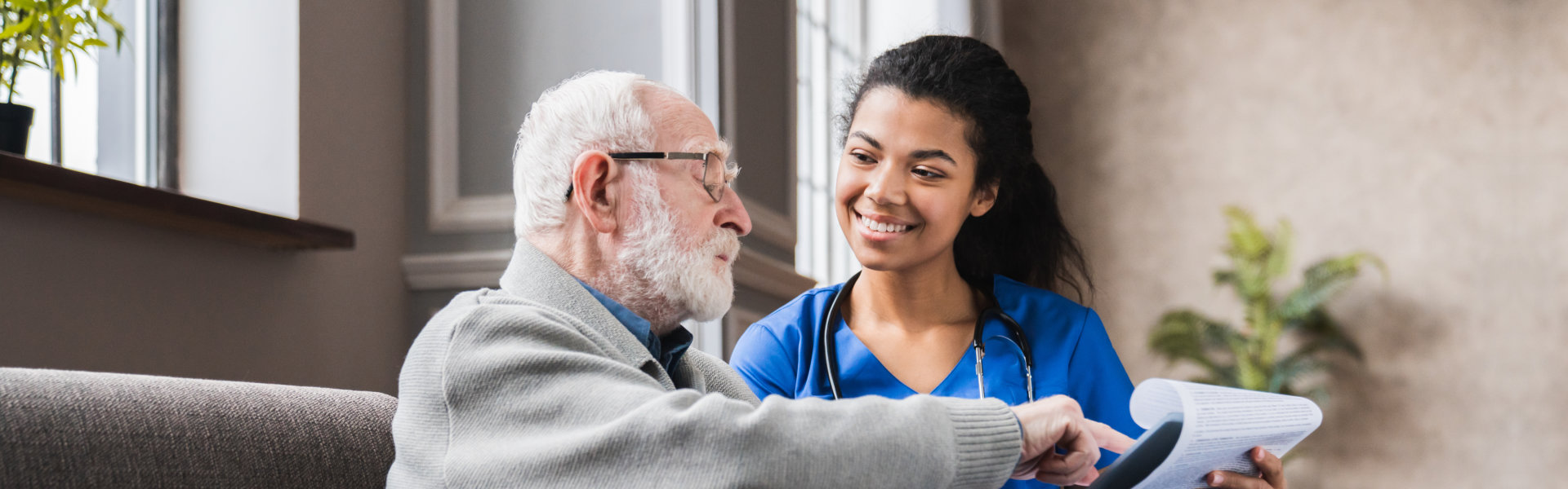 caretaker showing something to elderly